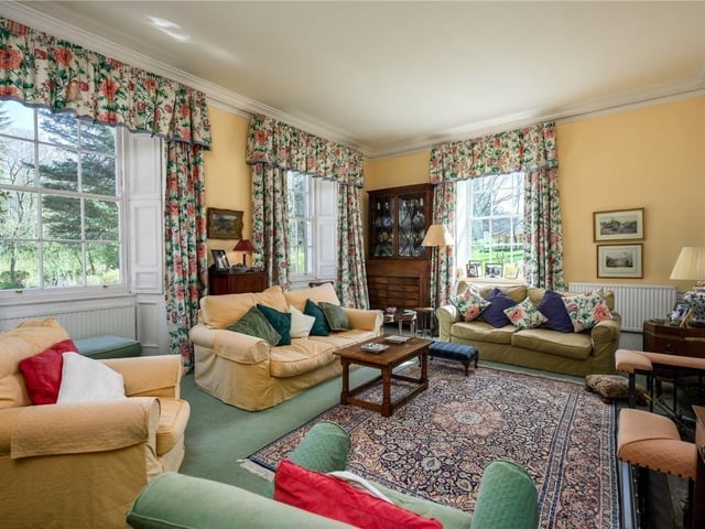 The beautifully proportioned drawing room overlooks the garden with southeast and northeast facing windows with working shutters and has an open fireplace and shelved alcove.