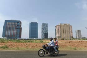 Men ride a motorbike at GIFT City, the emerging global financial and IT services hub in Gandhinagar, Gujarat, which offers several key incentives for global firms (Picture: Sam Panthaky/AFP via Getty Images)