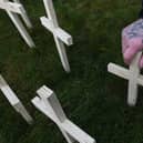 A man leaves a cross for his brother in Glasgow. Favor Scotland has planted 200 crosses on Valentine’s Day for drug death victims. Picture: John Devlin
