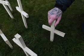 A man leaves a cross for his brother in Glasgow. Favor Scotland has planted 200 crosses on Valentine’s Day for drug death victims. Picture: John Devlin