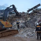 White Helmet Syrian rescue workers use an excavator to search amidst the rubble of collapsed building on February 6, 2022 in the town of Sarmada, in Syria's rebel-held northwestern Idlib province, as a search operation continues following a deadly earthquake. - At least 1,400 people were killed and 3,411 injured across Syria today in an earthquake that had its epicentre in southwestern Turkey, the government and rescuers said. (Photo by AAREF WATAD / AFP) (Photo by AAREF WATAD/AFP via Getty Images)