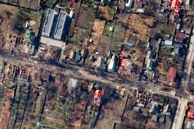 This satellite image provided by Maxar Technologies shows an overview of destroyed houses and vehicles in a street in Bucha