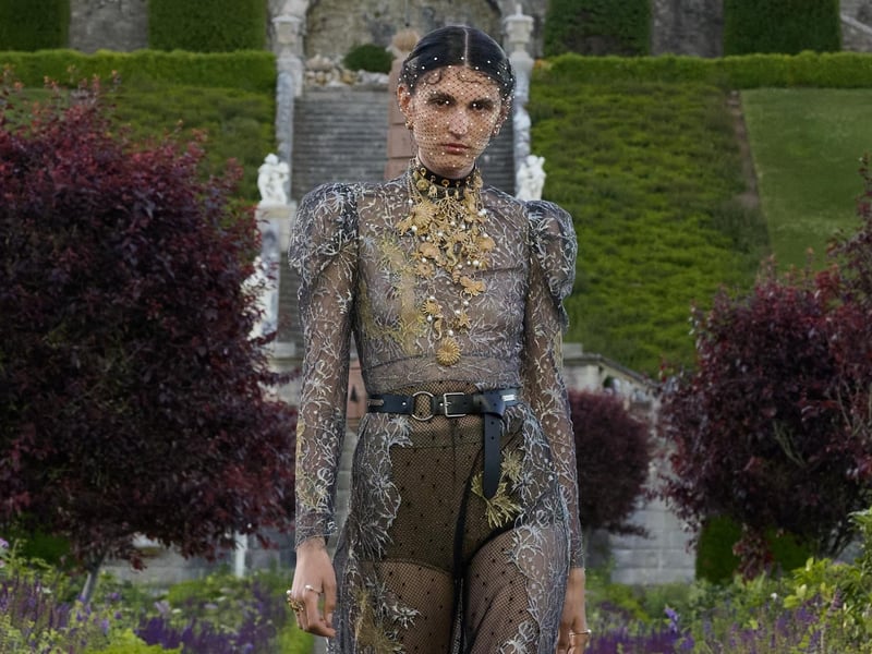 A heavily embellished and appliqued floor length transparent dress with leather belt.