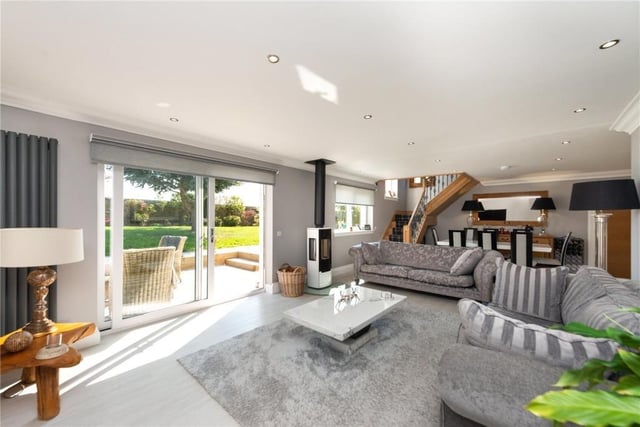 Living room with contemporary log burner and sliding doors leading out to a south facing terrace.