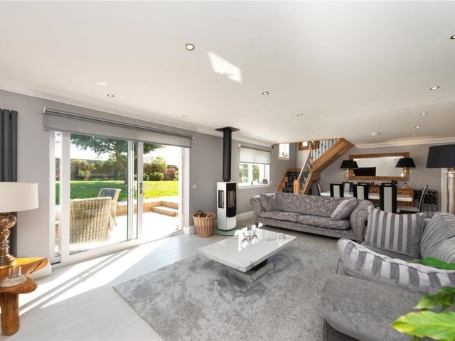 Living room with contemporary log burner and sliding doors leading out to a south facing terrace.