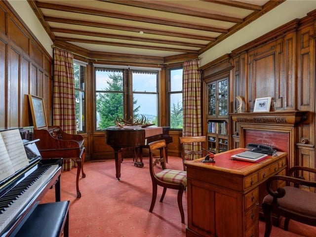 The characterful study has oak panelling, a carved fire surround and built in cabinetry, all in the Arts and Crafts style, while a bay window overlooks the garden and the city.