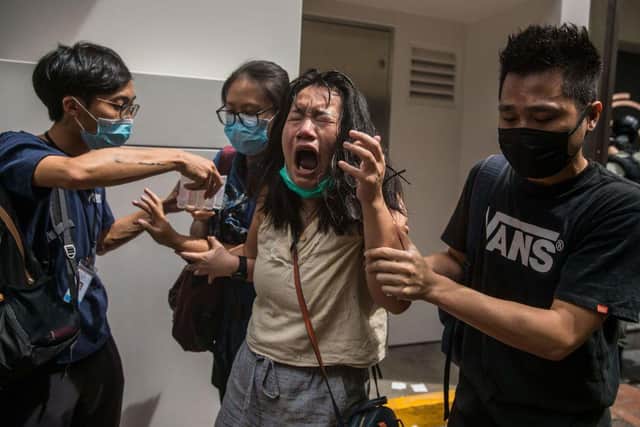 A woman reacts after she was hit with pepper spray deployed by police as they cleared a street with protesters (Photo: DALE DE LA REY/AFP via Getty Images)