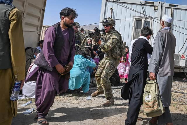 A US soldier point his gun towards an Afghan man among the crowds of people hoping to leave Afghanistan via Kabul airport following the Taliban victory (Picture: Wakil Kohsar/AFP via Getty Images)