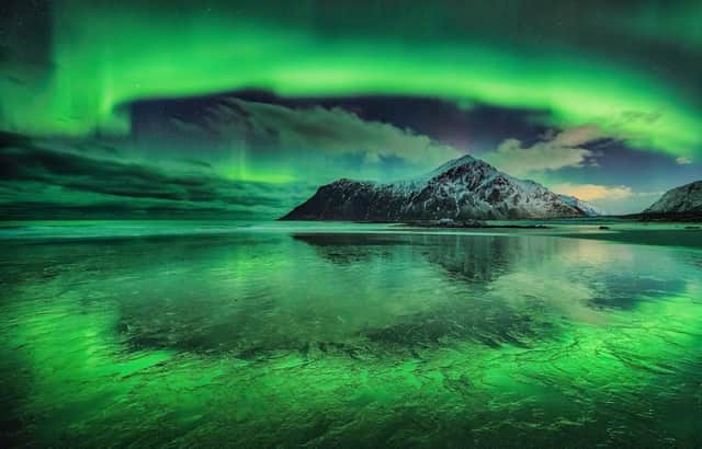 Runner-Up
Circle of Light  A stunning photograph of a vivid aurora over Skagsanden beach, Lofoten Islands, Norway. The mountain in the background is Hustinden, which the aurora appears to encircle. 

Taken with a Nikon Z7 camera, 15 mm f/2.8, ISO 1000, 8-second exposure
Location: Flakstad, Lofoten Islands, Norway
