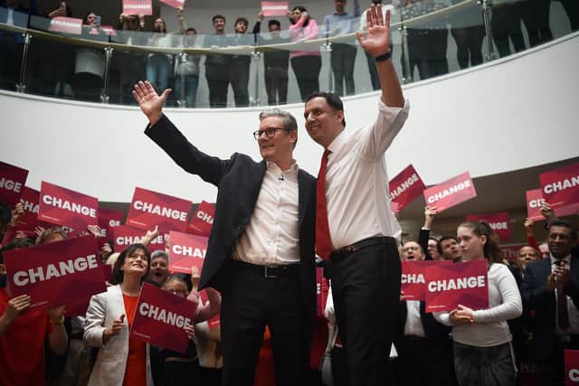 Keir Starmer and Scottish Labour Party leader Anas Sarwar wave at supporters in Glasgow (Photo by ANDY BUCHANAN/AFP via Getty Images)