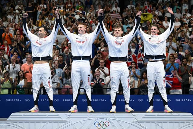 Gold medallists James Guy, Tom Dean, Matthew Richards and Duncan Scott celebrate on the podium after the men's 4x200m freestyle relay swimming final. (Photo by SEBASTIEN BOZON/AFP via Getty Images)