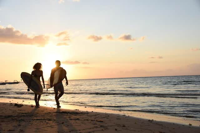 Surfers stroll along Tamarin bay at sunset. Pic: PA Photo/Veranda Tamarin.