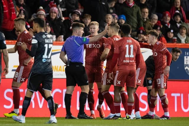 Aberdeen's Ross McCrorie (centre) appeals to referee Grant Irvine after he is sent off following a VAR check. (Photo by Ross Parker / SNS Group)