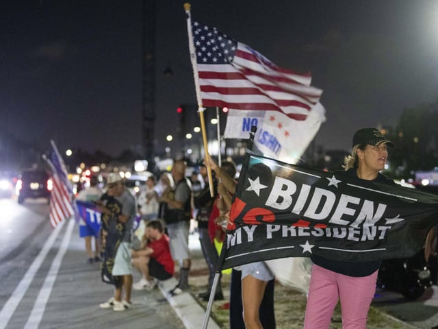 Jupiter resident Kathy Luksch, right, stands with others gathered to support former President Donald Trump on South Ocean Boulevard near Mar-a-Lago in Palm Beach. "How dare they!" Luksch said, referring to the FBI's raid on Mar-a-Lago.