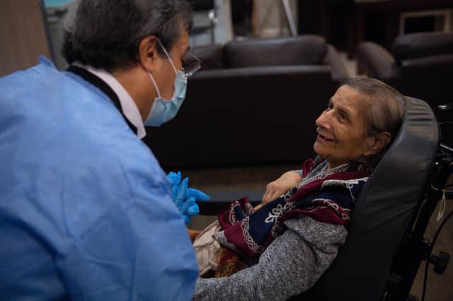 A care home resident talks to local GP staff after receiving an injection of the Covid-19 vaccine.