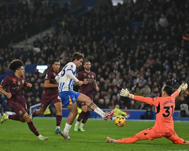Brighton's Matt O'Riley (C) scores their second goal past Manchester City's Brazilian goalkeeper Ederson.