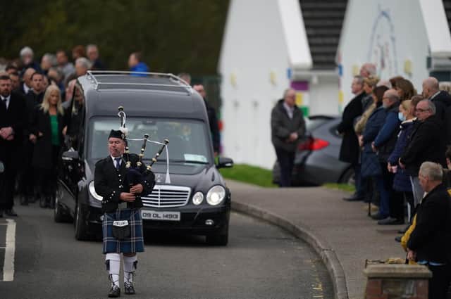 A piper plays as the hearse carrying Martin McGill, 49, arrives at St Michael's Church, Creeslough, for his funeral mass.