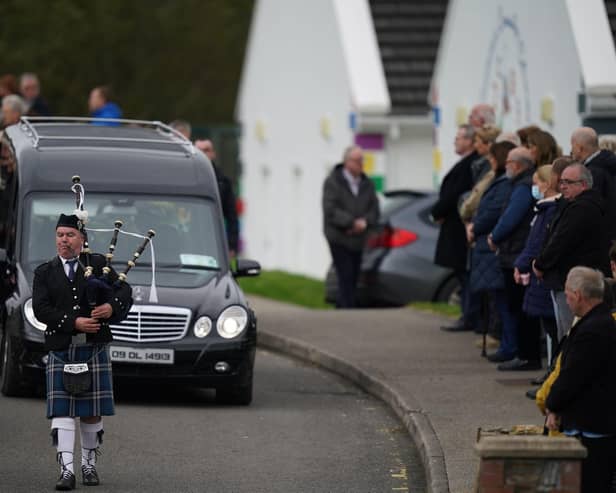 A piper plays as the hearse carrying Martin McGill, 49, arrives at St Michael's Church, Creeslough, for his funeral mass.