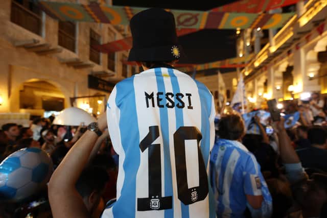 Fans of Argentina wear Lionel Messi shirts as they gather at Souk Waqif to show support to their team on the day before the final.