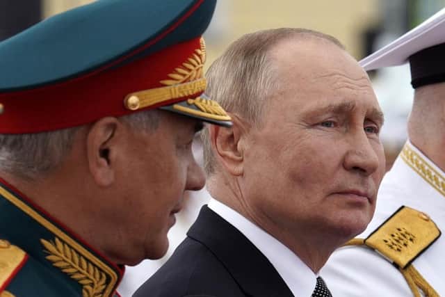 Russia's President Vladimir Putin sits next to Russia's Defence Minister Sergei Shoigu as he takes part in the main naval parade marking the Russian Navy Day, in St Petersburg.