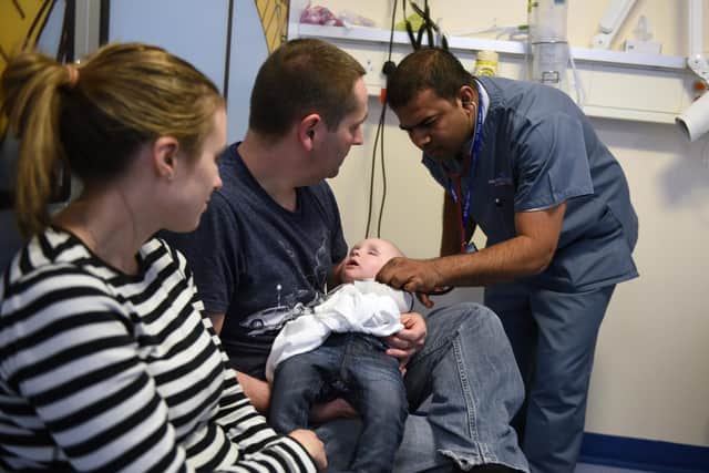A doctor attends to a young patient in the specialist Children's Accident and Emergency department of the 'Royal Albert Edward Infirmary' in Wigan, north west England on April 2, 2015. British Prime Minister David Cameron kicked off his re-election campaign Saturday, March 28, 2015, for May's tight poll by echoing his main rival with a new promise to improve the state-run National Health Service (NHS). Polling by Ipsos MORI indicates that the NHS, which provides across-the-board care for Britons and is mostly free, is the most important issue for voters. AFP PHOTO / OLI SCARFF        (Photo credit should read OLI SCARFF/AFP via Getty Images)