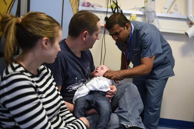 A doctor attends to a young patient in the specialist Children's Accident and Emergency department of the 'Royal Albert Edward Infirmary' in Wigan, north west England on April 2, 2015. British Prime Minister David Cameron kicked off his re-election campaign Saturday, March 28, 2015, for May's tight poll by echoing his main rival with a new promise to improve the state-run National Health Service (NHS). Polling by Ipsos MORI indicates that the NHS, which provides across-the-board care for Britons and is mostly free, is the most important issue for voters. AFP PHOTO / OLI SCARFF (Photo credit should read OLI SCARFF/AFP via Getty Images)