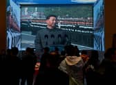 Visitors walk in front of a screen showing China's President Xi Jinping at the Museum of the Communist Party of China in Beijing (Picture: Noel Celis/AFP via Getty Images)