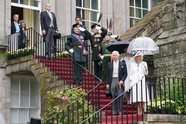 King Charles III, Queen Camilla and the Princess Royal (behind), pause on the steps for the National Anthem, as they host guests for a Garden Party at the Palace of Holyroodhouse. Picture: Jonathan Brady - WPA Pool/Getty Images