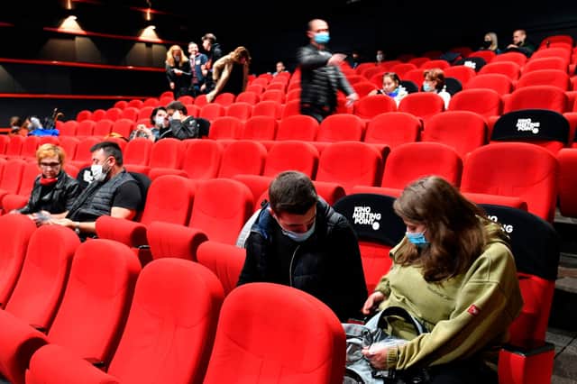People wearing protective face masks await the beginning of a cinema screening in Sarajevo. Picture: Elvis Barukic