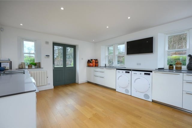 Utility room with fitted cabinets, television, and a door to the parking area.