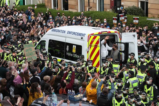 One of two men are released from the back of an Immigration Enforcement van accompanied by Mohammad Asif, director of the Afghan Human Rights Foundation, in Kenmure Street, Glasgow which is surrounded by protesters