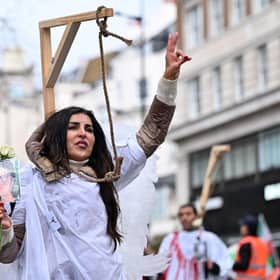 A protester poses in mock gallows during a rally held in central London this month against the Iranian regime (Picture: Justin Tallis/AFP via Getty Images)