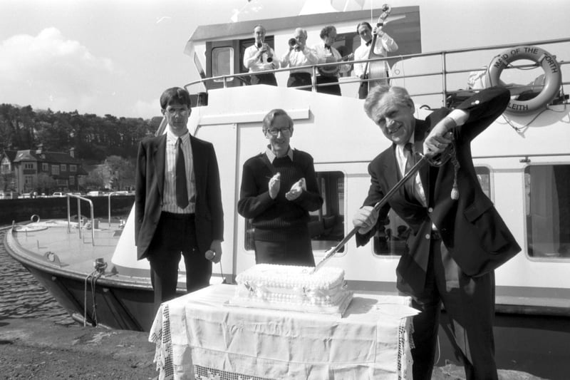Journalist, author and TV presenter Magnus Magnusson cuts the cake to celebrate the commissioning of the Maid of the Forth passenger ferry at the Firth of Forth, May 1988.