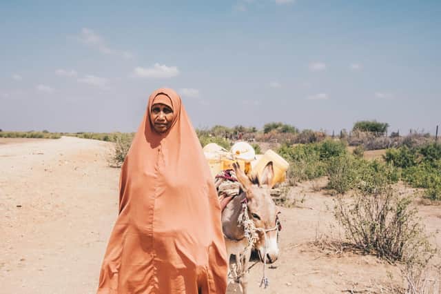 Asli Duqow returns home from fetching water in Wajir County, Kenya, where drought has caused a 70 per cent drop in crop production