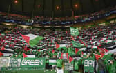Celtic fan group, the Green Brigade, hold up Palestine flags during the UEFA Champions League match against Atletico Madrid. (Photo by Rob Casey / SNS Group)