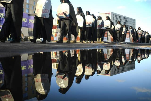 Protesters are seen carrying gravestones with the numbers of COP conferences claiming they have failed during a protest outside the entrance to the COP26 site in Glasgow.