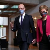 John Swinney, seen with Nicola Sturgeon, tests himself for Covid every time he leaves the house and is going to be in contact with other people (Picture: Russell Cheyne/pool/AFP via Getty Images)
