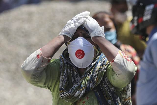 A relative of a person who died of COVID-19 reacts at a crematorium in Jammu, India.  (AP Photo/Channi Anand, File)