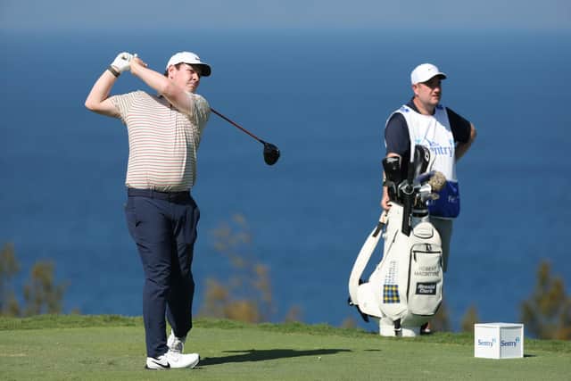 Bob MacIntyre tees off at the 13th hole watched by caddie Mike Burrow in the final round of The Sentry in Hawaii. Picture: Sarah Stier/Getty Images
