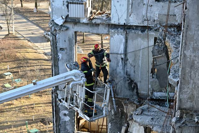 Workers attempt to make safe a residential building partially destroyed by shelling on the outskirts of Kharkiv, Ukraine (Picture: Sergey Bobok/AFP via Getty Images)