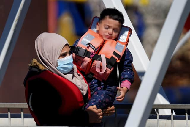 A distressed child is carried as a group of people thought to be migrants are brought in to Dover, Kent, from a Border Force Vessel, following a small boat incident in the Channel. Picture: Gareth Fuller/PA Wire