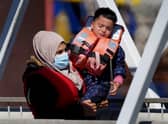 A distressed child is carried as a group of people thought to be migrants are brought in to Dover, Kent, from a Border Force Vessel, following a small boat incident in the Channel. Picture: Gareth Fuller/PA Wire