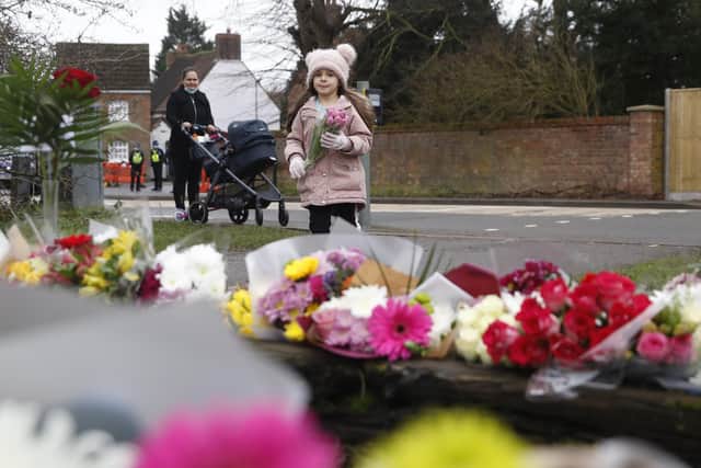 A young girl lays a floral tribute to Captain Sir Tom Moore in Marston Moretaine, England. Picture: AP Photo/Alastair Grant