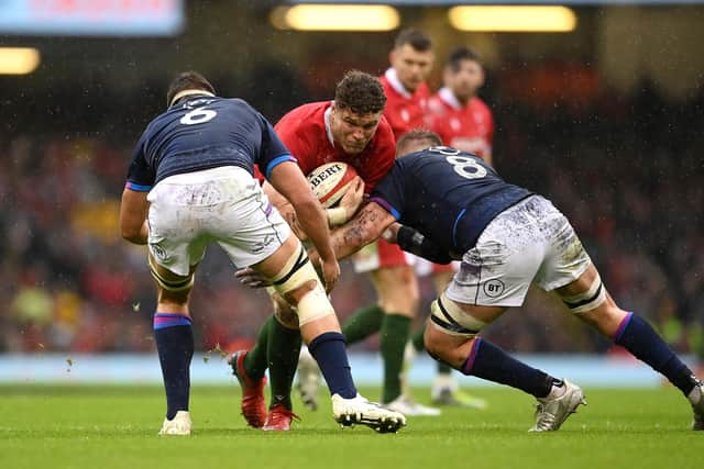 CARDIFF, WALES - FEBRUARY 12: Alex Cuthbert of Wales takes on Sam Skinner of Scotland and Matt Fagerson of Scotland during the Guinness Six Nations match between Wales and Scotland at Principality Stadium on February 12, 2022 in Cardiff, Wales. (Photo by Clive Mason/Getty Images)