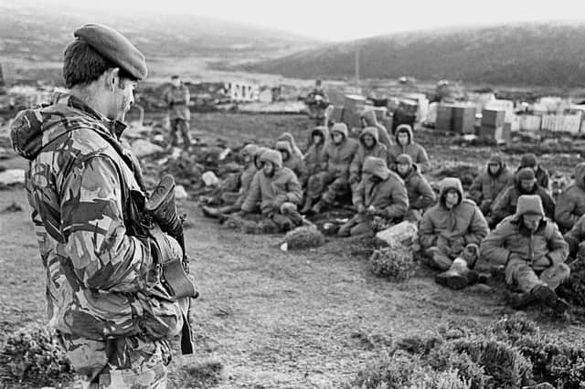 Argentinian soldiers captured at Goose Green on the Falkland Islands are guarded by a Royal Marine (Picture: PA)