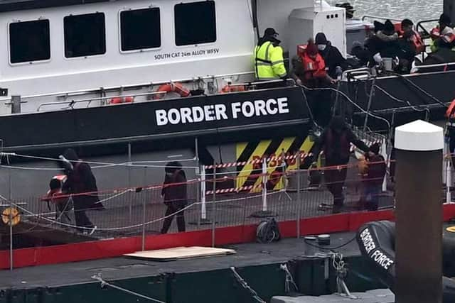 Migrants are escorted ashore from the UK Border Force vessel 'BF Ranger' in Dover, southeast England.