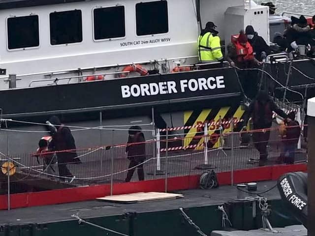 Migrants are escorted ashore from the UK Border Force vessel 'BF Ranger' in Dover, southeast England.