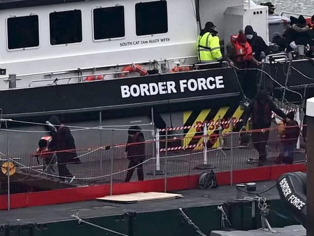 Migrants are escorted ashore from the UK Border Force vessel 'BF Ranger' in Dover, southeast England.