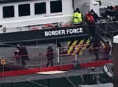 Migrants are escorted ashore from the UK Border Force vessel 'BF Ranger' in Dover, southeast England.