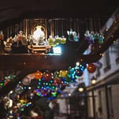 Festive ornaments hang down from a stall at a Christmas market